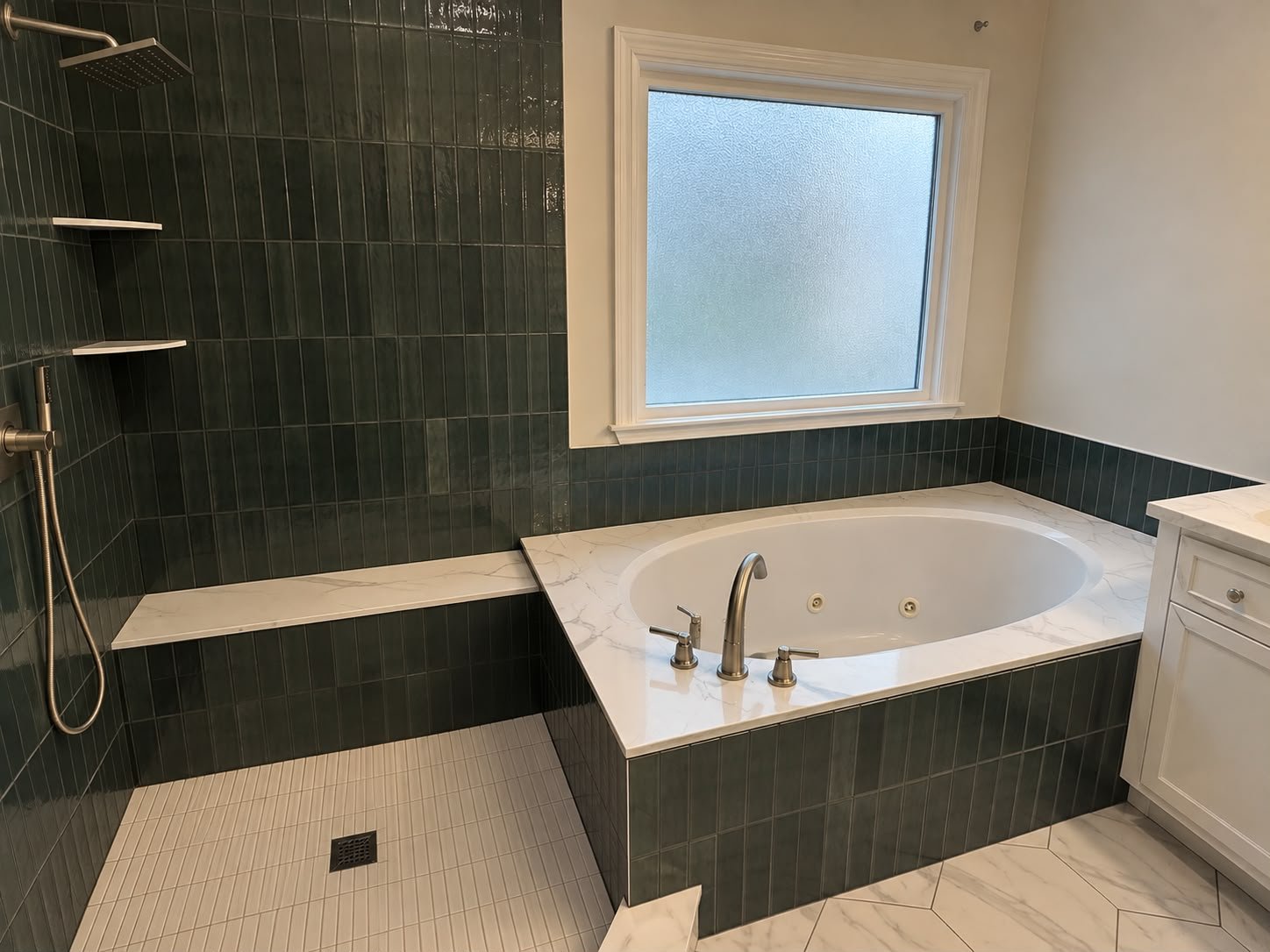 Completed custom bathroom with green tile, walk-in shower, bathtub and marble-look finishes